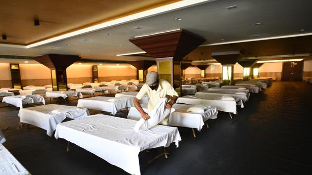 A man makes a bed in the hall at Shehnai Banquet opposite Lok Nayak Jai Prakash (LNJP) Hospital which has been requisitioned for use as a facility for coronavirus patients in New Delhi. (Vipin Kumar/HT PHOTO) A man makes a bed in the hall at Shehnai Banquet opposite Lok Nayak Jai Prakash (LNJP) Hospital which has been requisitioned for use as a facility for coronavirus patients in New Delhi. (Vipin Kumar/HT PHOTO)