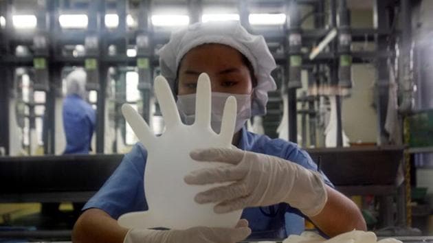 A worker carries out a test on a glove at a Top Glove factory in Meru outside Kuala Lumpur.(REUTERS File Photo)
