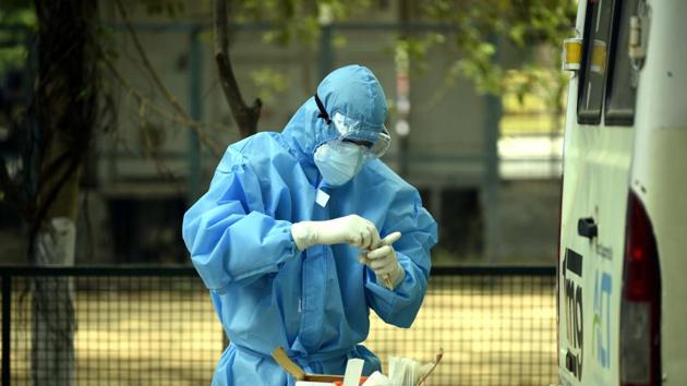 A health worker in a PPE bodysuit handles swab samples collected from police personnel for coronavirus testing in Police Lines, Gurugram.(Photo by Parveen Kumar / Hindustan Times) A health worker in a PPE bodysuit handles swab samples collected from police personnel for coronavirus testing in Police Lines, Gurugram.(Photo by Parveen Kumar / Hindustan Times)