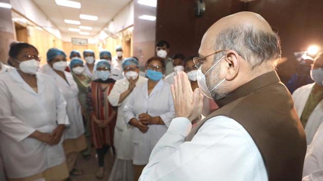 Union Home Minister Amit Shah gestures at the medical staff during his surprise visit to Lok Nayak Jai Prakash Narayan (LNJP) Hospital in New Delhi. (HT Photo) Union Home Minister Amit Shah gestures at the medical staff during his surprise visit to Lok Nayak Jai Prakash Narayan (LNJP) Hospital in New Delhi. (HT Photo)