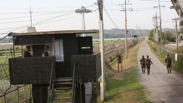 South Korean army soldiers patrol along the barbed-wire fence in Paju, near the border with North Korea on June 15. Earlier today, North Korean state media quoted the military as saying it has been studying an “action plan” to re-enter zones that had been demilitarized under a 2018 inter-Korean pact and “turn the front line into a fortress.” (Ahn Young-joon / AP)