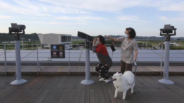 A visitor looks toward North’s side through binoculars at the Imjingak Pavilion in Paju, near the border village of Panmunjom on June 15. North Korea continues to lay the blame for the provocation on anti-Kim leaflets -- usually attached to hot air balloons or floated in bottles along will food, media content and currency bills -- flown across the border by South Korea-based activists. (Ahn Young-joon / AP)