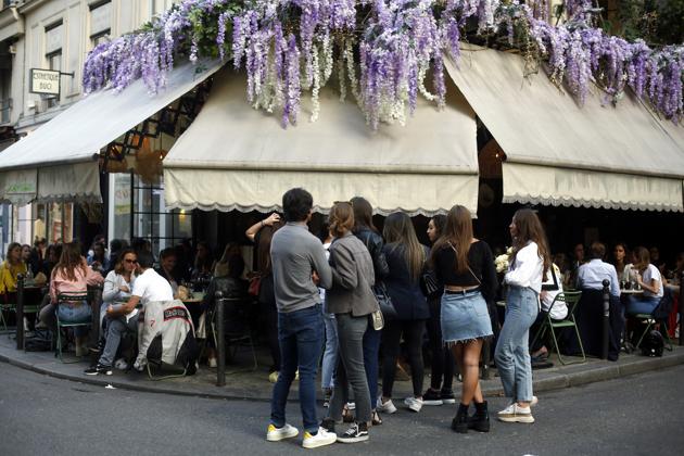 Customers queue outside a restaurant, Monday, June 15, 2020 in Paris. Paris is rediscovering itself, as its cafes and restaurants reopen for the first time since the fast-spreading virus forced them to close their doors March 14. Restaurants outside the Paris region opened earlier this month, and Paris cafes were allowed to serve people outside but not open their doors. After three months of losses, some restaurateurs fear it will take a long time for business to come back. (AP Photo/Thibault Camus) (AP)