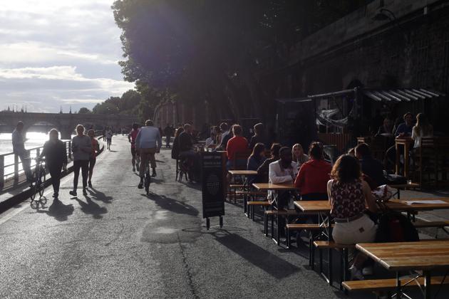 People sit on a cafe on the Seine river bank, Monday, June 15, 2020 in Paris. Paris is rediscovering itself, as its cafes and restaurants reopen for the first time since the fast-spreading virus forced them to close their doors March 14. Restaurants outside the Paris region opened earlier this month, and Paris cafes were allowed to serve people outside but not open their doors. After three months of losses, some restaurateurs fear it will take a long time for business to come back. (AP Photo/Thibault Camus) (AP)