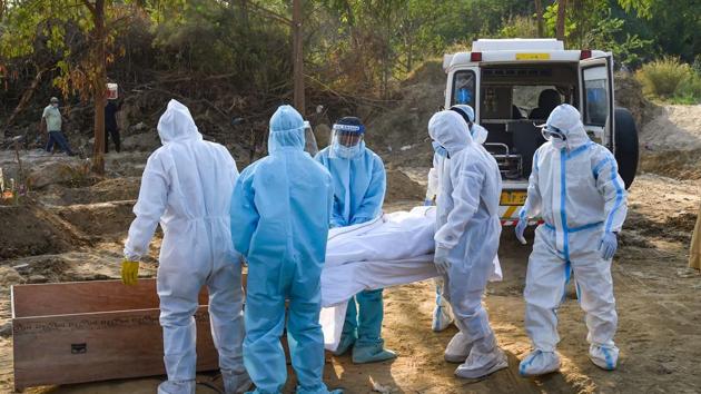 Relatives perform last rites of a family member who died of Covid -19 in New Delhi on Wednesday. (PTI) Relatives perform last rites of a family member who died of Covid -19 in New Delhi on Wednesday. (PTI)
