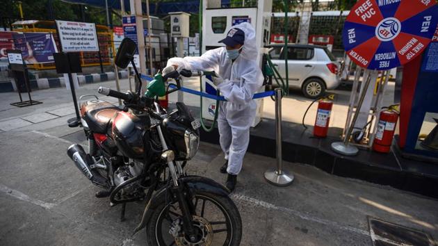 A petrol pump employee operates wearing PPE overalls. (Biplov Bhuyan/HT PHOTO) A petrol pump employee operates wearing PPE overalls. (Biplov Bhuyan/HT PHOTO)