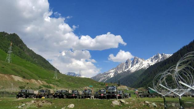 Indian army soldiers walk past their parked trucks at a makeshift transit camp before heading to Ladakh, near Baltal, southeast of Srinagar.(REUTERS)