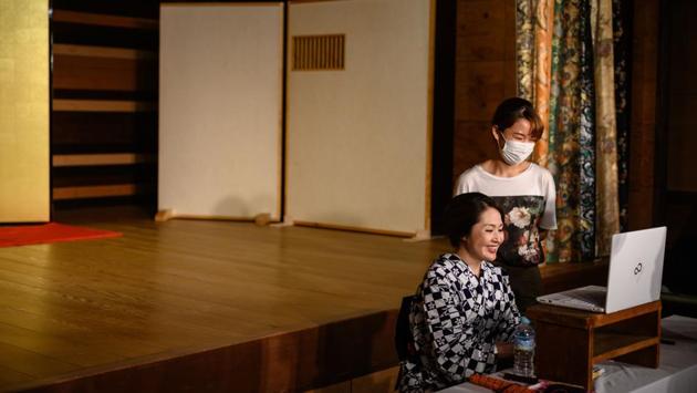 Chacha (front) prepares for an online Geisha party with Tamaki Nishimura (back), project manager of ‘Meet Geisha’, an online service for geisha meets in Hakone on June 13. “Usually we are very busy in April, May and June,” Chacha told AFP. “But this year, we have no parties, zero.” The pandemic evaporated incomes for geishas like Chacha who now eagerly awaits the arrival of government stimulus funds. (Philip Fong / AFP) Chacha (front) prepares for an online Geisha party with Tamaki Nishimura (back), project manager of ‘Meet Geisha’, an online service for geisha meets in Hakone on June 13. “Usually we are very busy in April, May and June,” Chacha told AFP. “But this year, we have no parties, zero.” The pandemic evaporated incomes for geishas like Chacha who now eagerly awaits the arrival of government stimulus funds. (Philip Fong / AFP)