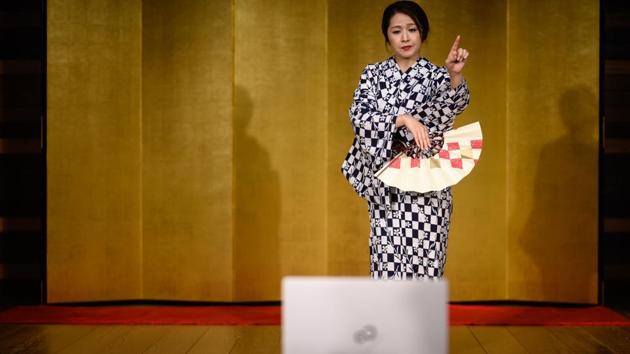 “Chacha,” who asks to be identified by a pseudonym, performs for an online drinking party with clients in Hakone, Japan on June 13. Beneath spotlights, the 32-year-old geisha performs traditional dances, moving like a butterfly and artfully unfolding and fluttering her fan. (Philip Fong / AFP) “Chacha,” who asks to be identified by a pseudonym, performs for an online drinking party with clients in Hakone, Japan on June 13. Beneath spotlights, the 32-year-old geisha performs traditional dances, moving like a butterfly and artfully unfolding and fluttering her fan. (Philip Fong / AFP)