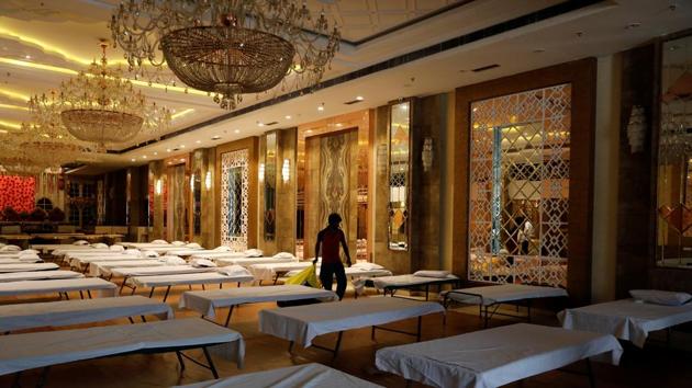 A man walks past beds inside a banquet hall used for weddings after it was temporarily converted into a makeshift quarantine facility for patients diagnosed with the coronavirus disease (Covid-19), in New Delhi. (REUTERS) A man walks past beds inside a banquet hall used for weddings after it was temporarily converted into a makeshift quarantine facility for patients diagnosed with the coronavirus disease (Covid-19), in New Delhi. (REUTERS)