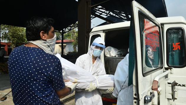 Chand Mohammad along with his fellows carries the body of a person who died of COVID-19 at a crematorium in New Delhi on June 15. “I took the job after I exhausted all my options to find work. This is a dangerous job, as I am at a higher risk of contracting the infection, but I need the job,” Mohammad told PTI. (Arun Sharma / PTI) Chand Mohammad along with his fellows carries the body of a person who died of COVID-19 at a crematorium in New Delhi on June 15. “I took the job after I exhausted all my options to find work. This is a dangerous job, as I am at a higher risk of contracting the infection, but I need the job,” Mohammad told PTI. (Arun Sharma / PTI)