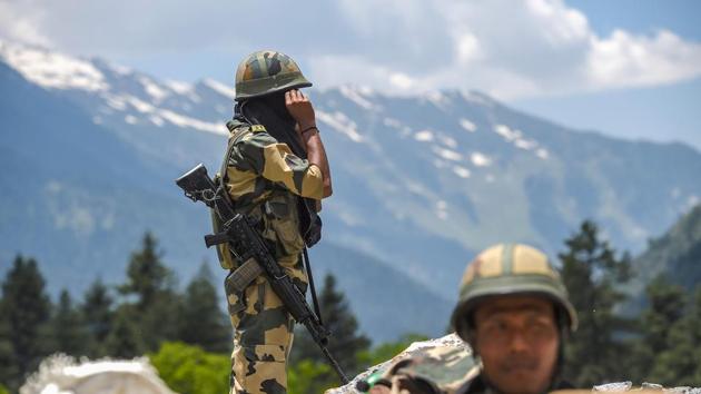 Security force personnel stand guard along the Srinagar-Leh National highway, in Ganderbal district of Kashmir, on Wednesday.(PTI Photo)