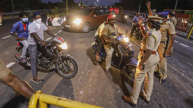 Police personnel stop commuters at a barricade for screening at East Coast road (ECR), in Chennai on June 15. In the new lockdown beginning June 19, flights and trains services will continue, but autos and taxis can only ply for essential services and medical emergencies in the four districts. (PTI) 