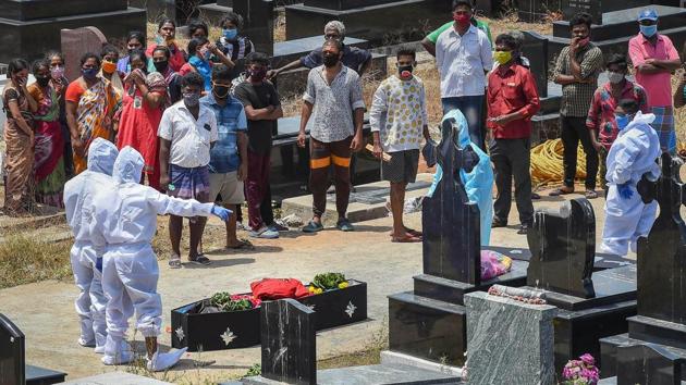 Health workers and relatives perform the last rites of a COVID19 victim at a Christian cemetery in Chennai on June 14. Tamil Nadu is also pushing ahead in terms of testing. With 25,463 tests, the daily testing figures crossed the 25,000 benchmark in the state for the first time on June 17, the state health department said. (PTI) 