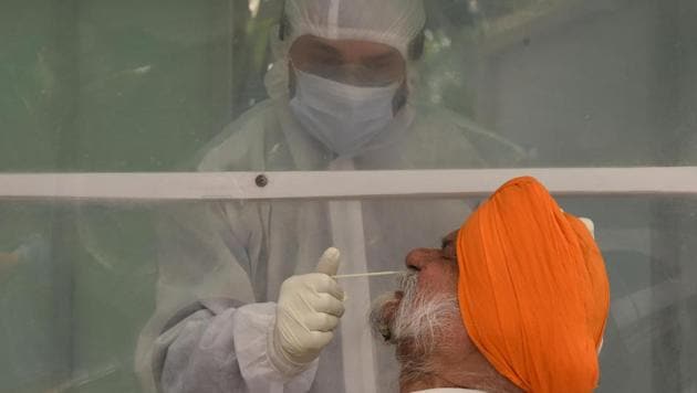 A health worker in an enclosed booth collects a swab sample from a man for coronavirus testing at Park Plaza Delhi CBD Shahdara, in New Delhi. (Sonu Mehta/HT PHOTO) A health worker in an enclosed booth collects a swab sample from a man for coronavirus testing at Park Plaza Delhi CBD Shahdara, in New Delhi. (Sonu Mehta/HT PHOTO)