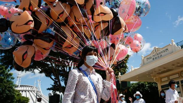 An employee holds balloons at Disneyland Resort in Hong Kong. Shanghai’s Disneyland, which is attracting visitors from outside the city, reopened in May. (Tyrone Siu / REUTERS) An employee holds balloons at Disneyland Resort in Hong Kong. Shanghai’s Disneyland, which is attracting visitors from outside the city, reopened in May. (Tyrone Siu / REUTERS)