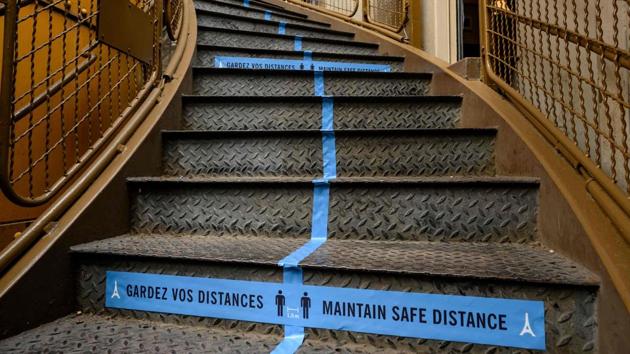 Safety distance signs are seen on the steps of the Eiffel tower on June 15. Visitors will not be able to go any higher than the second level of the tower and until the start of July,  and access will be only via the staircases. The elevators, with their confined space, present a risk of disease transmission. (Bertrand Guay / AFP) 