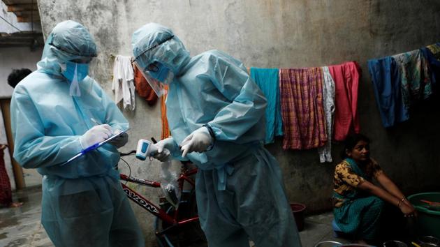 Healthcare workers write down details of residents in a slum during a check-up camp for the coronavirus disease (Covid-19) in Mumbai.(REUTERS)