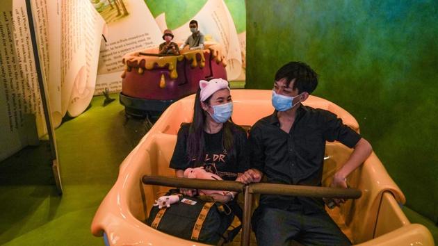 Visitors wearing protective masks head onto the ‘Many Adventures of Winnie the Pooh’ ride. The shopping and dining locations operated on a reduced capacity along with social distancing measures implemented throughout its facilities. (Lam Yik / Bloomberg) Visitors wearing protective masks head onto the ‘Many Adventures of Winnie the Pooh’ ride. The shopping and dining locations operated on a reduced capacity along with social distancing measures implemented throughout its facilities. (Lam Yik / Bloomberg)