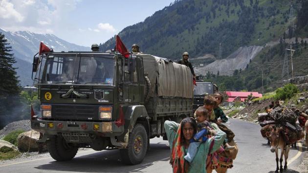 Kashmiri Bakarwal nomads walk as an Indian army convoy moves on the Srinagar- Ladakh highway at Gagangeer, north-east of Srinagar, India, Wednesday, June 17, 2020.(AP)