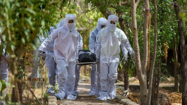 Health workers and volunteers from SDPI wearing personal protective equipments (PPE) carry the body of a COVID-19 victim for burial in Chennai on June 16. The state recorded its highest spike of 2,174 cases yesterday. With 48 new deaths, the toll from the virus stands at 576. (R Senthil Kumar / PTI) 