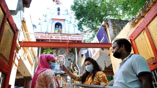 Devotees undergo thermal screening before entering Mankameshwar temple after it reopened for public for the first time since the nationwide lockdown was imposed to curb the spread of coronavirus, in Lucknow, Uttar Pradesh. (Photo by Deepak Gupta / Hindustan Times)