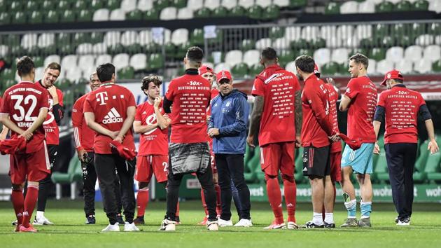 Bayern's head coach Hansi Flick, center, talks to his players after winning the German Bundesliga soccer match between Werder Bremen and Bayern Munich in Bremen, Germany, Tuesday, June 16, 2020. Bayern became champion for the 30th time in Germany. Because of the coronavirus outbreak all soccer matches of the German Bundesliga take place without spectators. (AP Photo/Martin Meissner, Pool)(AP)