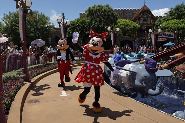 Iconic Disney characters Minnie and Mickey Mouse cheer up visitors at the Disneyland Resort in Hong Kong after it reopened to the public on June 18 for the first time in nearly five months due to the coronavirus pandemic (COVID-19). (Kin Cheung / AP) Iconic Disney characters Minnie and Mickey Mouse cheer up visitors at the Disneyland Resort in Hong Kong after it reopened to the public on June 18 for the first time in nearly five months due to the coronavirus pandemic (COVID-19). (Kin Cheung / AP)
