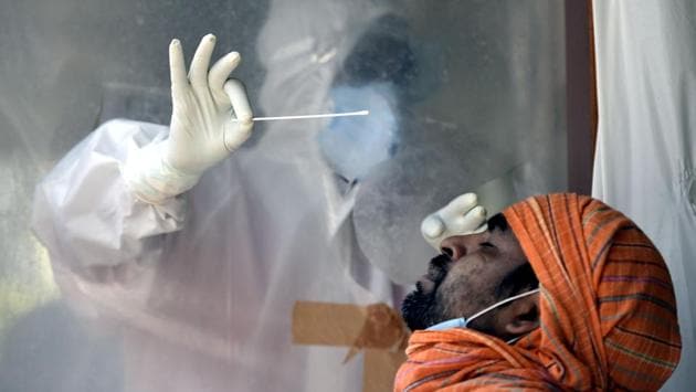 A health worker collects a swab sample in Patel Nagar on June 18. The antigen diagnostic test, which takes just 30 minutes to produce results, was approved for use in India on June 15. The government has already received 50,000 of the 6 lakh kits ordered. (Vipin Kumar / HT Photo)