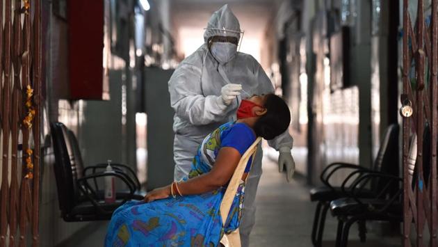 A woman gives a nasopharyngeal swab for Covid-19 Ag antigen testing in Nangal Raya on June 18. The tests began on a day the government announced that lab tests will be capped at ₹2,400, a day after it was suggested by a committee formed by the Union government. (Sanchit Khanna / HT Photo)