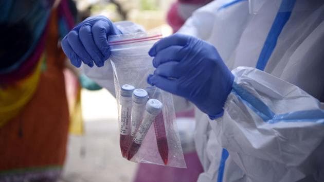 A health worker handles swab samples collected for COVID-19 testing on June 17. Apart from being quicker than lab-based RT-PCR tests, the antigen tests being employed now are cheaper – one kit costs ₹450 – and differ in technology as they look for specific protein associated with the Sars-Cov-2 virus, the pathogen that causes Covid-19. (Parveen Kumar / HT Photo)