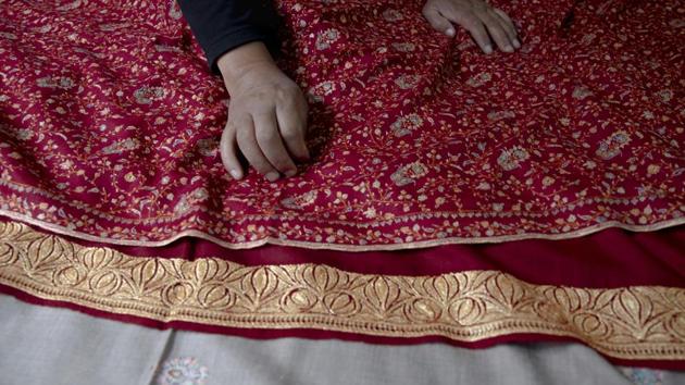 An artisan checks the quality of a pashmina shawl inside his home in Srinagar, Indian controlled Kashmir, Saturday, June 13, 2020. (AP)