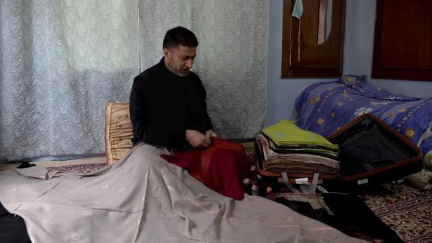Abdul Later Allie, a Kashmiri artisan, checks the quality of pashmina shawls inside his home in Srinagar. (AP)