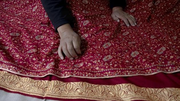 An artisan checks the quality of a pashmina shawl inside his home in Srinagar, Indian controlled Kashmir, Saturday, June 13, 2020.(AP)