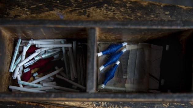 Pashmina threads spun on plastic straws lie inside a wooden box near a loom in Srinagar, Indian controlled Kashmir. (AP)