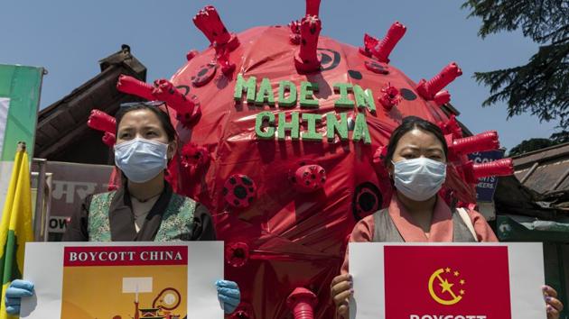 Exile Tibetan activists hold banners next to a giant installation depicting the coronavirus during a street demonstration by the Tibetan Youth Congress asking for a boycott of Chinese goods in Dharmsala, India, Tuesday, June 16, 2020. (AP Photo/Ashwini Bhatia)(AP)