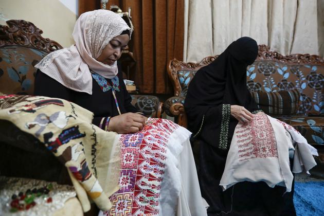 Um Zeid, 47 year-old, and Khawla 48 year-old, Palestinian refugees women living in Jordan embroider a traditional Palestinian dresses for customers. (REUTERS)