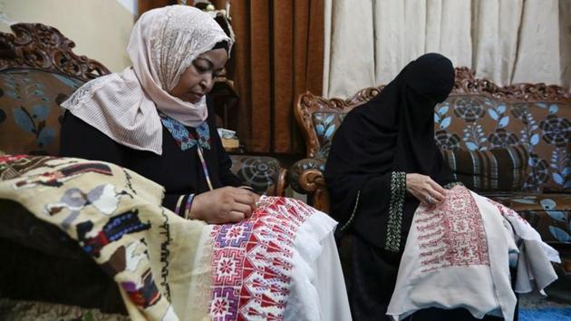 Um Zeid, 47 year-old, and Khawla 48 year-old, Palestinian refugees women living in Jordan embroider a traditional Palestinian dresses for customers at Al-Baqaa Palestinian refugee camp, near Amman, Jordan, June 16, 2020.(REUTERS)