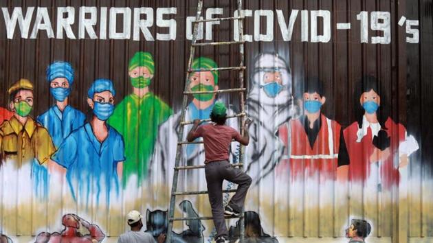 A man gets off a ladder as he completes a mural paying tribute to 'Covid-19 warriors' as India eases lockdown restrictions that were imposed to slow the spread of the coronavirus disease(REUTERS)