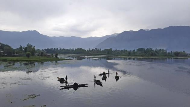 Kashmiri labourers are cleaning the Nigeen Lake in Srinagar.(Waseem Andrabi/ HT)