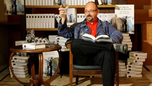 FILE PHOTO: Spanish writer Carlos Ruiz Zafon drinks a toast during a photo call before the presentation of his new book titled El Juego del Angel (The game of the Angel )(REUTERS/Gustau Nacarino)
