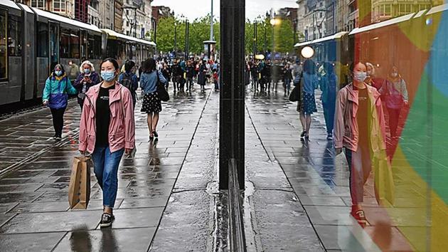 A woman wears a facemask she walks down a street in Manchester, north west England (AFP) A woman wears a facemask she walks down a street in Manchester, north west England (AFP)