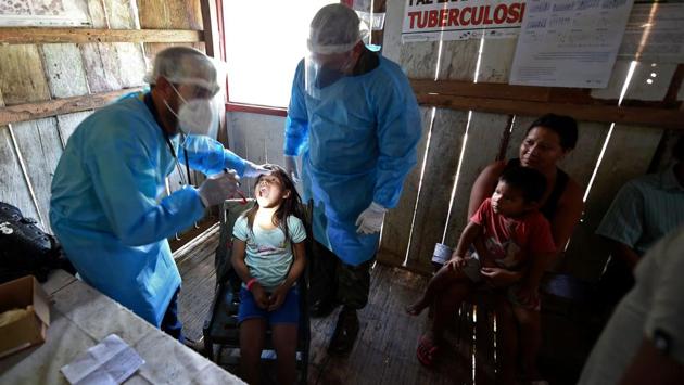 Doctors check an indigenous child from the Mayoruna ethnic group in Cruzeirinho village, Amazonas state on June 18. Official data shows a downward trend of the virus in Brazil’s north, including the hard-hit region of the Amazon, a plateau in cases and deaths in the countries’ biggest cities near the Atlantic coast, but a rising curve in the south. (Evaristo Sa / AFP) Doctors check an indigenous child from the Mayoruna ethnic group in Cruzeirinho village, Amazonas state on June 18. Official data shows a downward trend of the virus in Brazil’s north, including the hard-hit region of the Amazon, a plateau in cases and deaths in the countries’ biggest cities near the Atlantic coast, but a rising curve in the south. (Evaristo Sa / AFP)