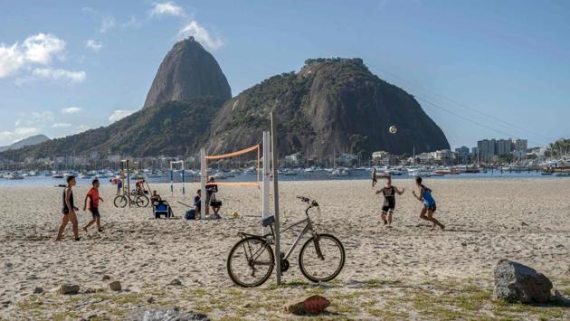 People play volleyball despite a prohibition on collective sport activities at the Botafogo beach in Rio de Janeiro. Brazilian President Jair Bolsonaro still downplays the risks of the virus, saying the impact of social isolation measures on the economy could be worse than the disease itself. Specialists believe the actual number of cases in Brazil could be up to seven times higher than the official statistic. (Mauro Pimentel / AFP) People play volleyball despite a prohibition on collective sport activities at the Botafogo beach in Rio de Janeiro. Brazilian President Jair Bolsonaro still downplays the risks of the virus, saying the impact of social isolation measures on the economy could be worse than the disease itself. Specialists believe the actual number of cases in Brazil could be up to seven times higher than the official statistic. (Mauro Pimentel / AFP)