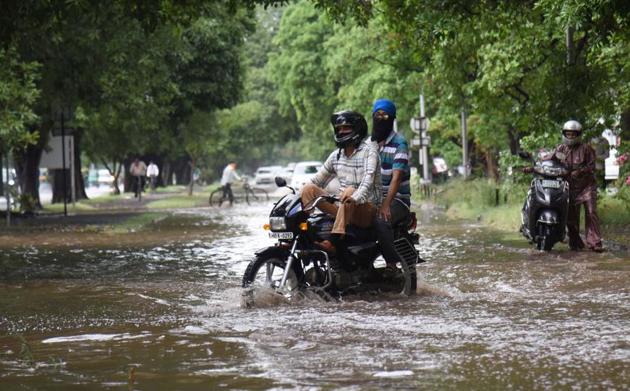 Commuters make way through an inundated road in Sector 9, Chandigarh, on Friday.(Ravi Kumar/HT) Commuters make way through an inundated road in Sector 9, Chandigarh, on Friday.(Ravi Kumar/HT)