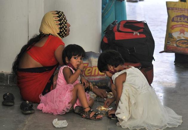 Children catch a lunch break while waiting for screening before boarding the Shramik Special train, at Chandigarh College of Engineering and Technology in Sector 26 on Friday.(Ravi Kumar/HT)