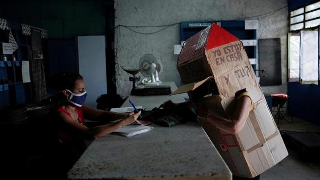 Retired Cuban nurse Feridia Rojas, 82, wears cardboard shaped into a house.(REUTERS) Retired Cuban nurse Feridia Rojas, 82, wears cardboard shaped into a house.(REUTERS)