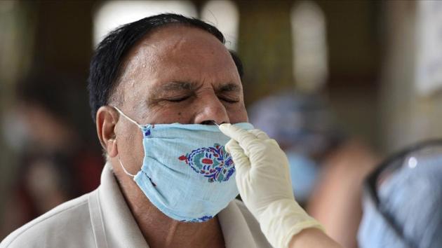 A medic collects swab sample from a man to test for COVID-19 infection, in New Delhi on June 19. It took the National Capital 110 days since the first case to touch the 50,000-mark. (Kamal Kishore / PTI) A medic collects swab sample from a man to test for COVID-19 infection, in New Delhi on June 19. It took the National Capital 110 days since the first case to touch the 50,000-mark. (Kamal Kishore / PTI)
