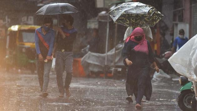 People walk under umbrellas amid rain showers, near Jama Masjid in New Delhi on May 31, 2020.(Sanchit Khanna/HT PHOTO) People walk under umbrellas amid rain showers, near Jama Masjid in New Delhi on May 31, 2020.(Sanchit Khanna/HT PHOTO)