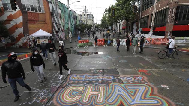 People walk past street art that reads "Welcome to CHAZ" inside what is being called the "Capitol Hill Autonomous Zone" in Seattle. (AP) People walk past street art that reads "Welcome to CHAZ" inside what is being called the "Capitol Hill Autonomous Zone" in Seattle. (AP)